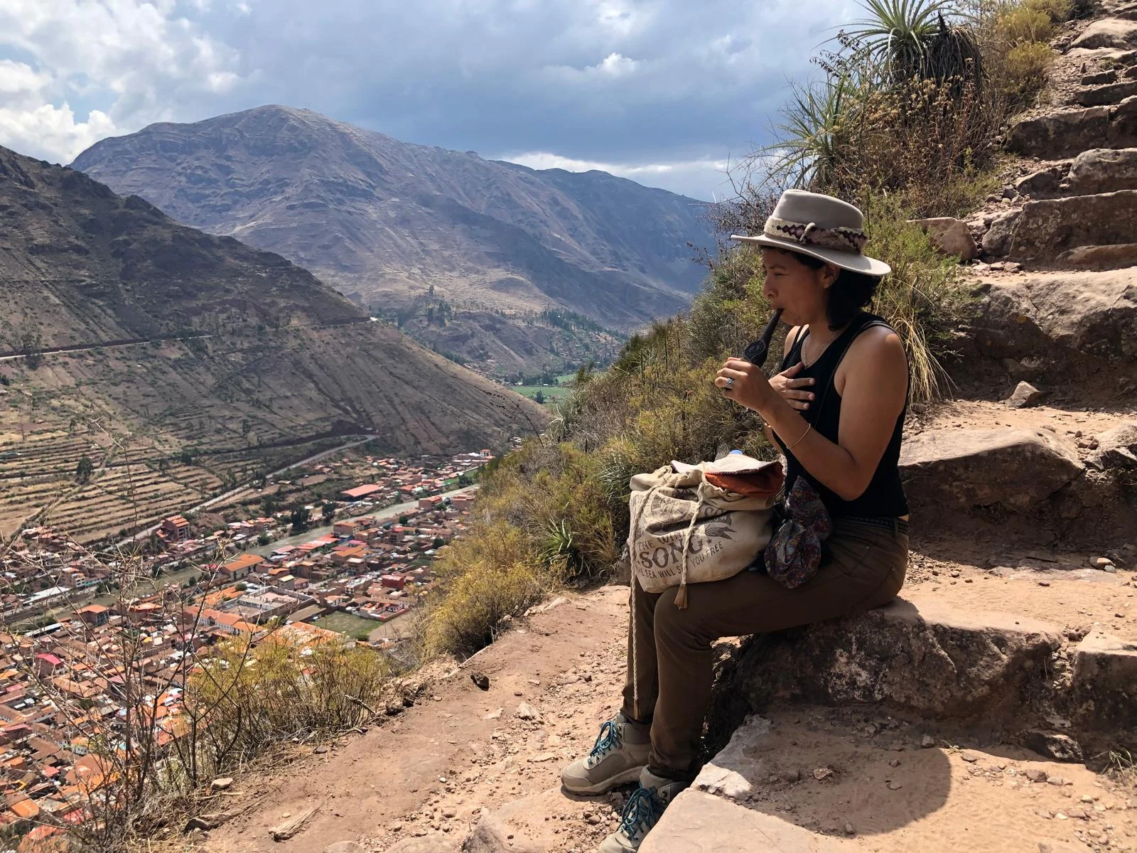 Mar using a kuripe pipe on ancient stone steps overlooking the Sacred Valley in the Andes