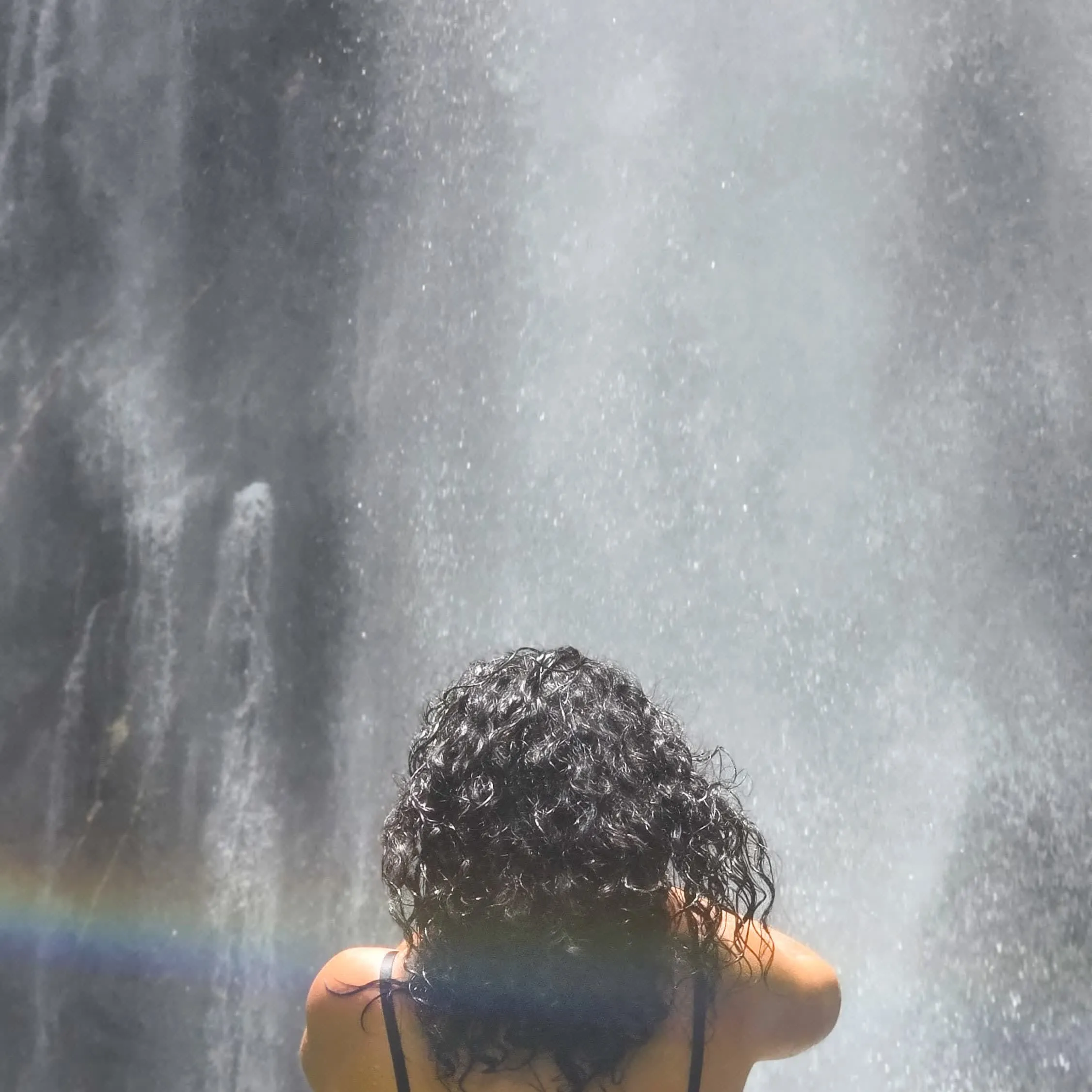 Mar facing a waterfall with rainbow in the mist
